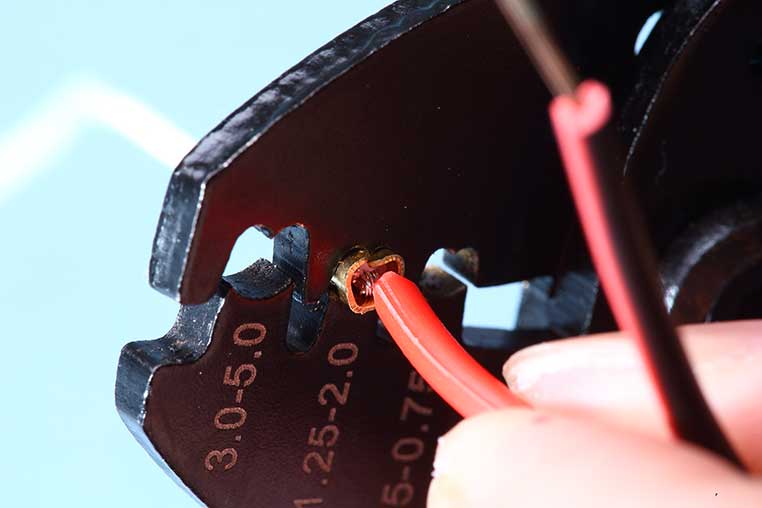 電工ペンチの小さいハート形の穴を使い、スプライス端子を圧着させる