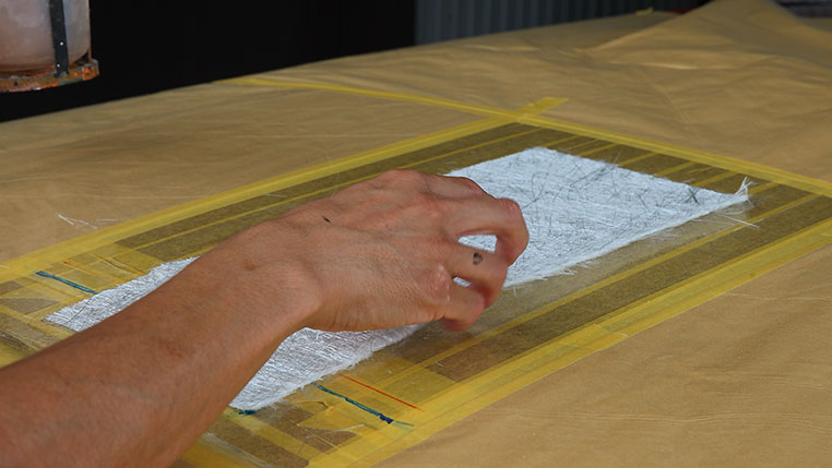 FRP繊維マットに樹脂の溶液を均一に染みこませる作業、2枚目を重ねて載せる